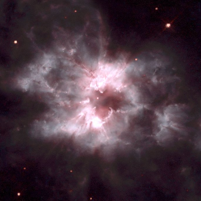 NGC 2440 is another planetary nebula ejected by a dying star, but it has a much more chaotic structure than NGC 2346. The central star of NGC 2440 is one of the hottest known, with a surface temperature near 200,000 degrees Celsius. The complex structure of the surrounding nebula suggests to some astronomers that there have been periodic oppositely directed outflows from the central star, somewhat similar to that in NGC2346, but in the case of NGC 2440 these outflows have been episodic, and in different directions during each episode. The nebula is also rich in clouds of dust, some of which form long, dark streaks pointing away fromthe central star. In addition to the bright nebula, which glows becauseof fluorescence due to ultraviolet radiation from the hot star, NGC 2440 is surrounded by a much larger cloud of cooler gas which is invisible in ordinary light but can be detected with infrared telescopes. NGC 2440 lies about 4,000 light-years from Earth in thedirection of the constellation Puppis. The Hubble Heritage team made this image from observations of NGC 2440acquired by Howard Bond (STScI) and Robin Ciardullo (Penn State). Credit: NASA/ESA and The Hubble Heritage Team (AURA/STScI).