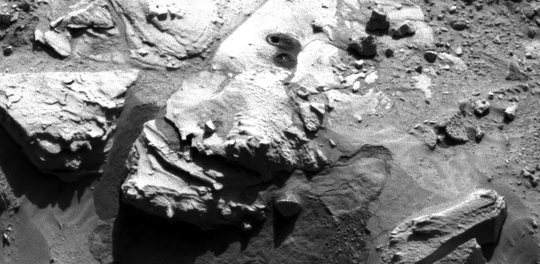 This image from the Navigation Camera (Navcam) on NASA's Curiosity Mars rover shows two holes at top center drilled into a sandstone target called "Windjana." The farther hole, with larger pile of tailings around it, is a full-depth sampling hole. It was created by the rover's hammering drill while the drill collected rock-powder sample material from the interior of the rock. The nearer hole was created by a shallower test drilling into the rock in preparation for the sample collection. Each hole is 0.63 inch (1.6 centimeters) in diameter. The full-depth hole is about 2.6 inches (6.5 centimeters) deep, drilled during the 621st Martian day, or sol, of Curiosity's work on Mars (May 5, 2014). The test hole is about 0.8 inch (2 centimeters) deep, drilled on Sol 615 (April 29, 2014). This image was taken on Sol 621 (May 5). The sandstone target's informal name comes from Windjana Gorge in Western Australia. The rock is within a waypoint location called "The Kimberley," where sandstone outcrops with differing resistance to wind erosion result in a stair-step pattern of layers. Windjana is within what the team calls the area's "middle unit," because it is intermediate between rocks that form buttes in the area and lower-lying rocks that show a pattern of striations. NASA's Jet Propulsion Laboratory, a division of the California Institute of Technology, Pasadena, manages the Mars Science Laboratory Project for NASA's Science Mission Directorate, Washington. JPL designed and built the project's Curiosity rover and the rover's Navcam. Credit: NASA/JPL-Caltech